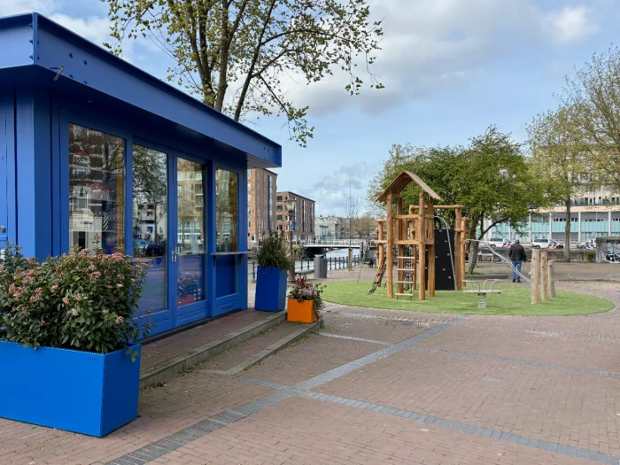 Bright blue coffee kiosk with small children's playground next to it