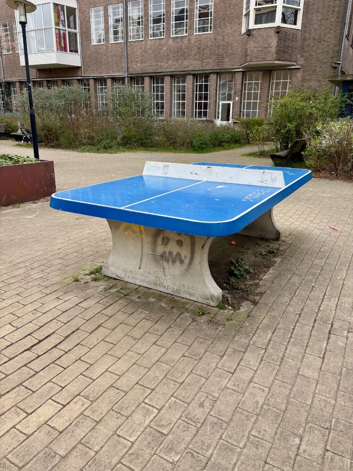 Blue outdoor table tennis table with concrete base