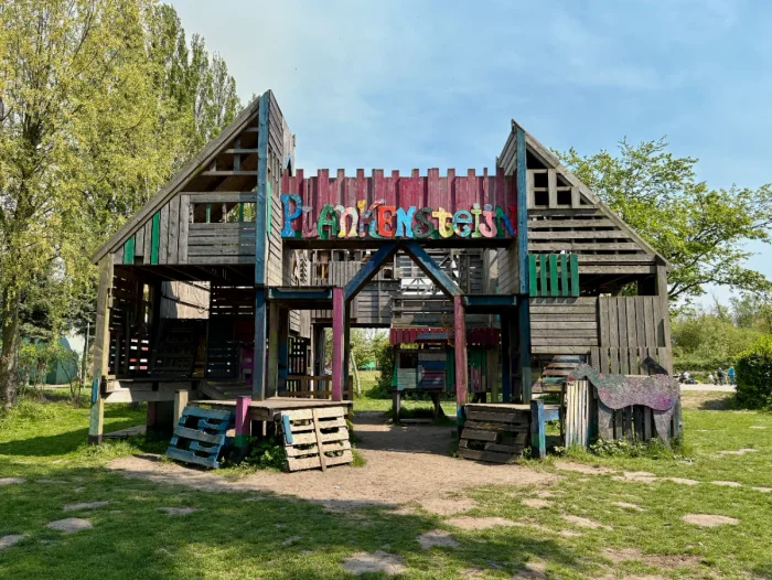 Colorful handmade wooden house and play structure made out of palettes