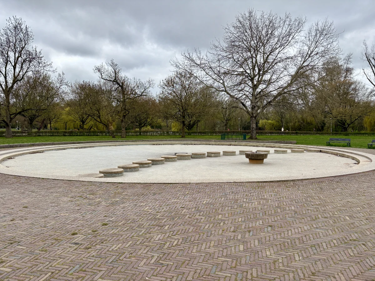 Large round drained paddling pool with concrete stepping stones
