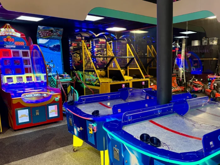 Arcade with basketball game, air hockey table, and go-karts parked in the back