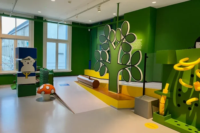 Play area with green cartoon tree cutout and red-capped mushroom