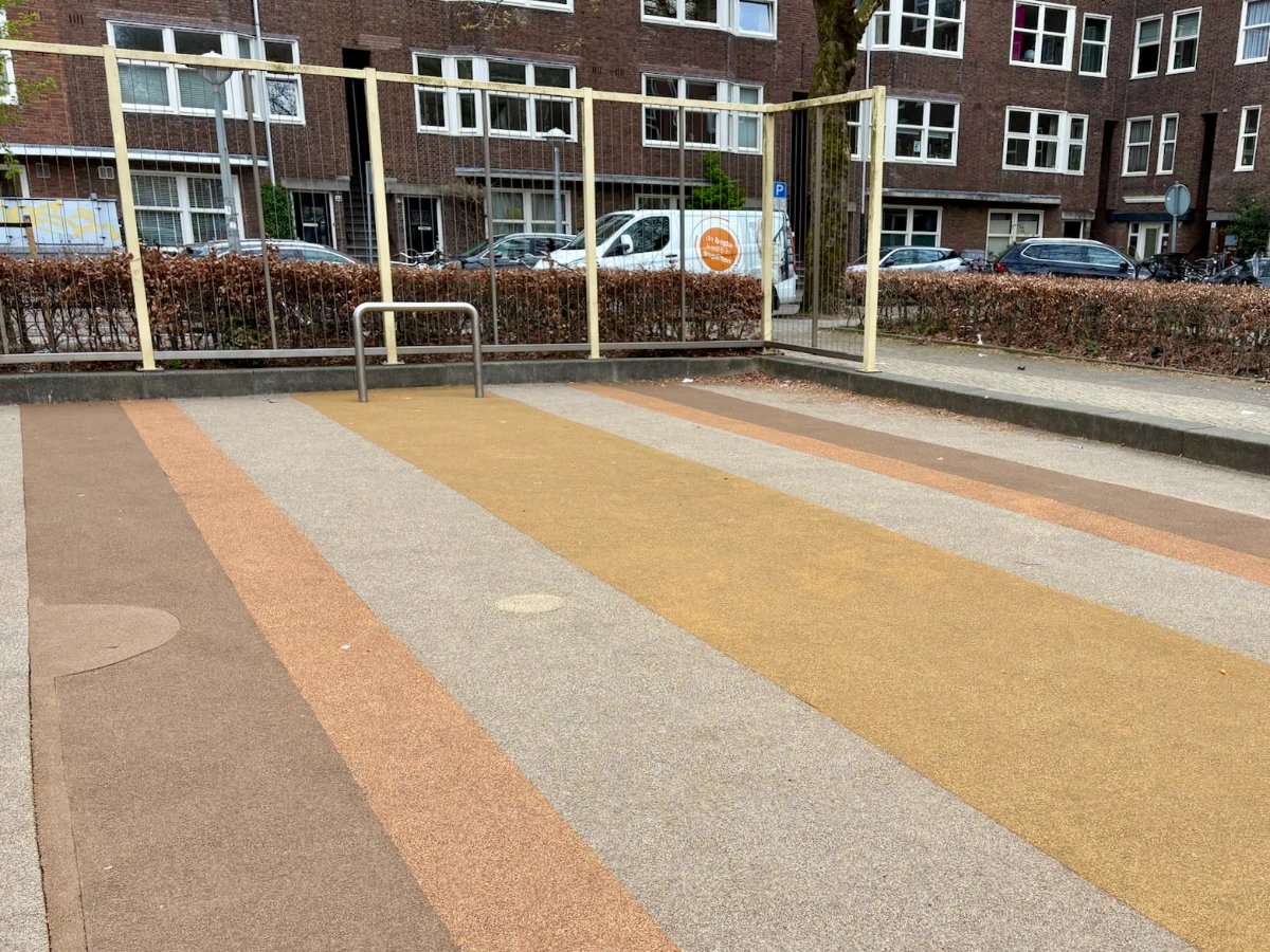 Yellow, grey, and orange striped mini football pitch with yellow metal enclosure