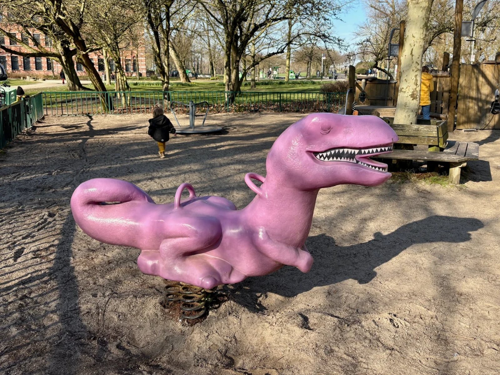 Hot pink T-Rex Dinosaur rocker at children's playground