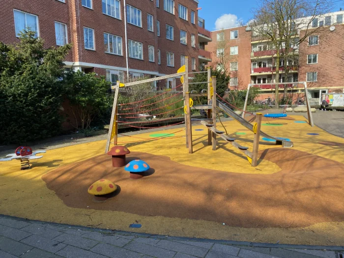 Yellow and orange playground with wooden play structure and slide and colorful toadstools