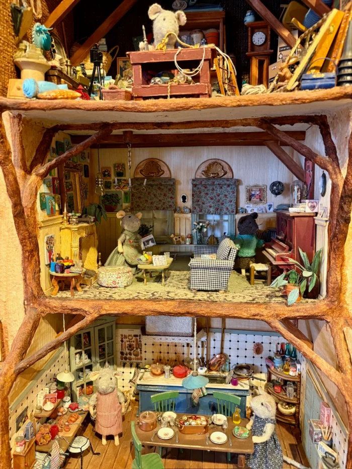 Whimsical, handmade miniature house inhabited by a family of mice with a kitchen, living room, and workshop