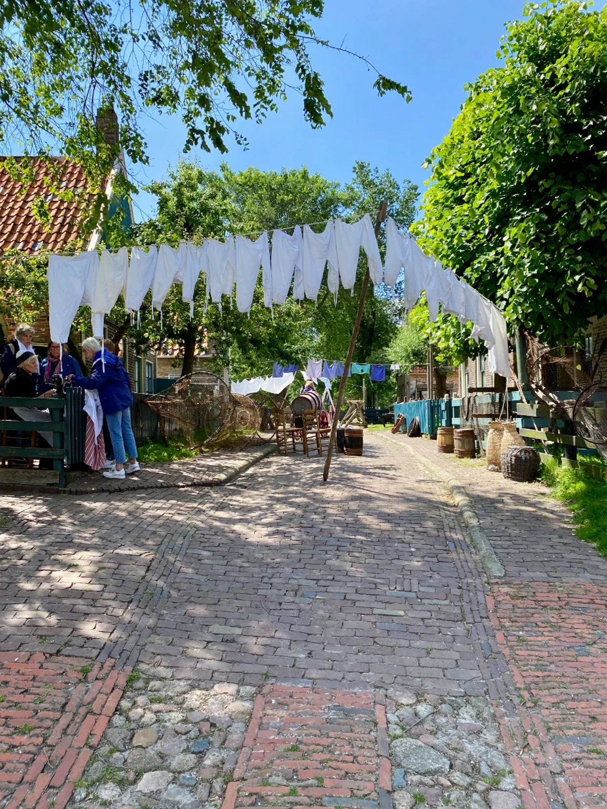Old brick street with a laundry link across it and white undergarments hanging
