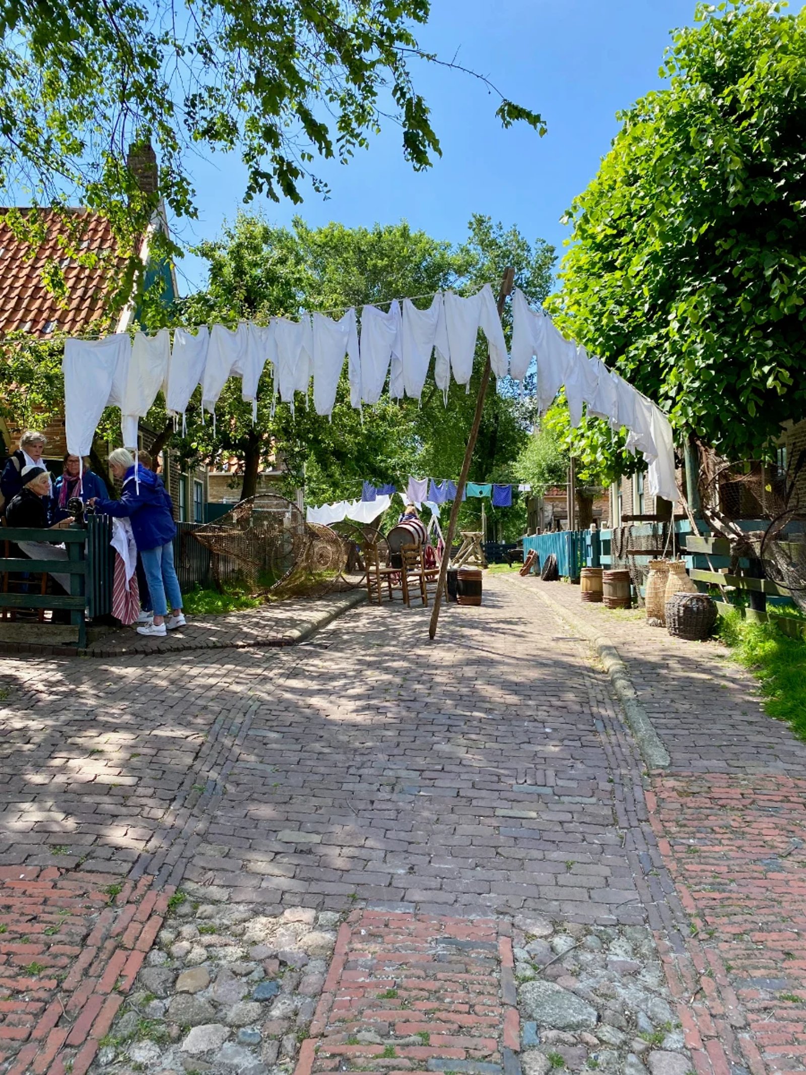 Old brick street with a laundry link across it and white undergarments hanging